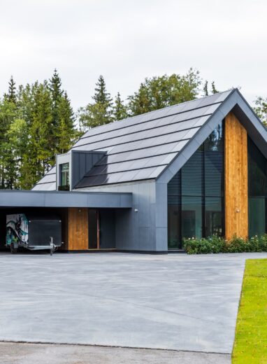 beautiful, aesthetic solar roof on a house with garage, trees and pavement by Solarstone